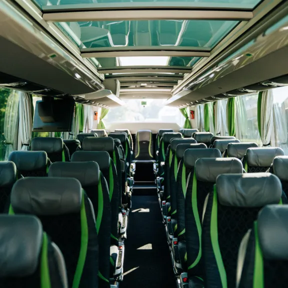 (4)	Bus-Innenraum eines Schröder Busses mit grau-grünen Sitzen.